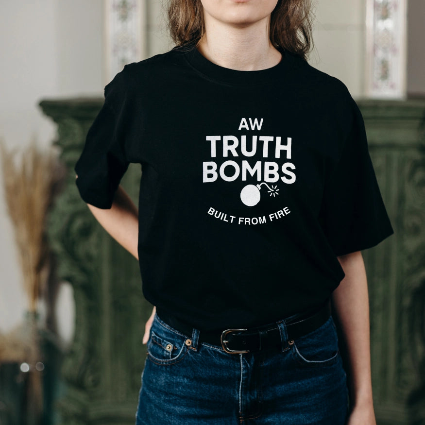Woman wearing AW Truth Bombs Built from Fire Black T-shirt